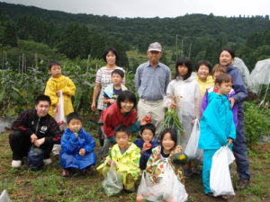 3日目、笛木和子さんの畑の前にて。たくさんの野菜を収穫させてもらいました。
